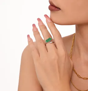 Gros plan sur une bague ajustable en argent avec zircons verts portee par un mannequin