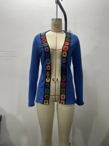 Detail of navy ribbed knit cardigan with colorful crochet floral appliqué borders