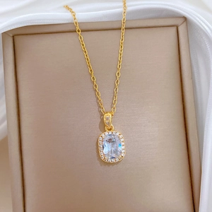 Elegant gold titanium square zircon necklace displayed on beige silk inside a jewelry box