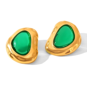 Close-up of vintage irregular 18k gold earrings with green translucent resin inlay