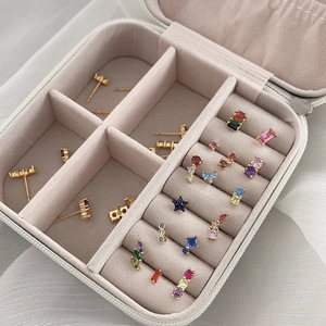 Detail shot of travel jewelry box with colorful zircon star and geometric stud earrings