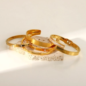Lot de quatre bracelets en acier inoxydable doré avec zircons et motif bambou