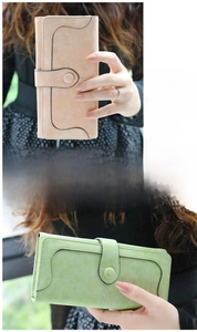 Detalle de cartera larga vintage de cuero suave con cierre de presión y costuras onduladas