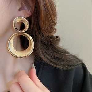 Macro shot of large double-layered golden hoops with detailed radial textured finish