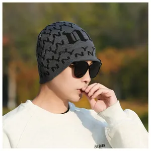 Detailed knit texture of a grey beanie with black jacquard N patterns and Gothic D letter