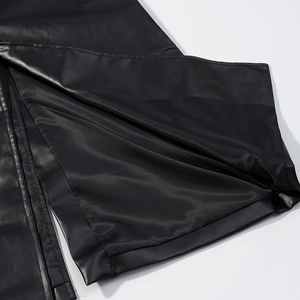 Close-up of black PU leather coat hem featuring split design and premium stitching