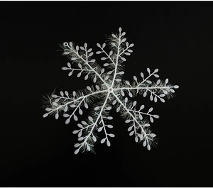 Detailed view of a white glittery snowflake ornament with intricate fiber texture