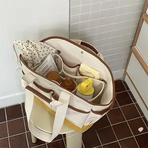 Top view of canvas diaper bag interior with multi-compartments and baby supplies