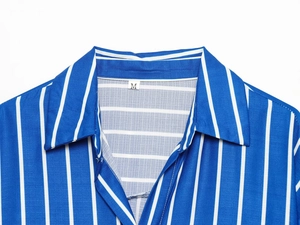 Détail du col d'une chemise à rayures bleues et blanches avec étiquette taille M