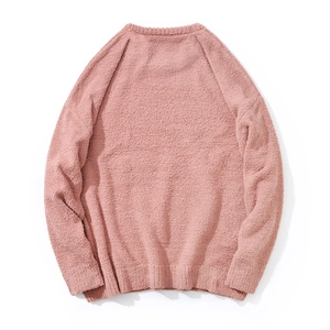 Detailed close-up of pink knit sweater showing soft boucle texture and ribbed hem