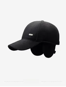 Detail view of winter baseball cap with earflaps and metal plaque on thick wool fabric
