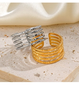 Detailed view of gold and silver multi-layer rings with hammered texture on silk fabric