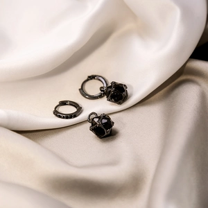 Vintage geometric black rhinestone earrings on white silk background with macro view