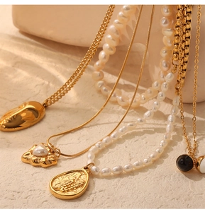Macro detail of vintage gold plated pendant necklaces and freshwater pearl jewelry layers