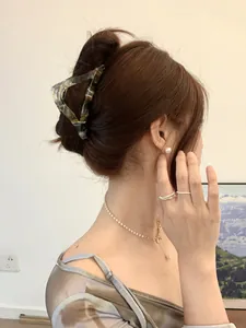 Elegant woman wearing amber tortoise shell hair claw clip with pearl jewelry set
