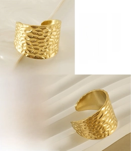 Detail view of gold stainless steel ring featuring textured hammered surface and open design