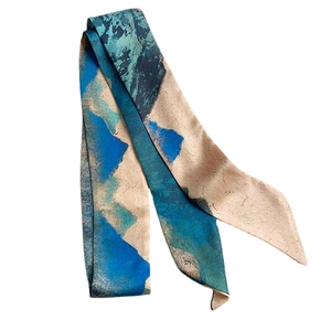 Foulard en soie élégant avec motif de paysage bleu et beige exposé à plat sur blanc