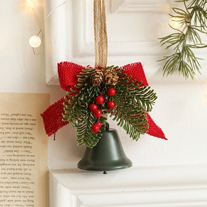 Christmas iron bell ornament with red bow, pine cones and berries on a rustic rope