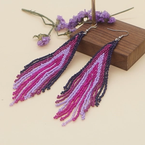 Handmade bohemian beaded tassel earrings in purple gradient with metal ear hooks
