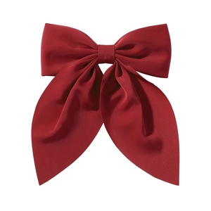 Minimalist deep red bow hair clip with matte fabric texture shown on a white background