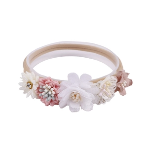Detailed view of baby headband featuring handmade floral clusters on soft nylon band