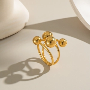 Detailed view of gold minimalist double-ring with polished beads and metallic finish
