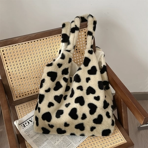 Detail of soft heart-pattern plush tote bag with fuzzy texture on a vintage chair