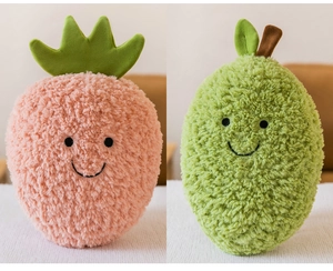 Dettaglio dei peluche a forma di fragola rosa e frutto verde con simpatici sorrisi