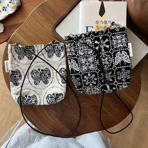 Détail de la broderie fleur papillon sur l'ensemble de sacs en toile rétro