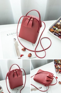 Detail view of mini red faux leather crossbody bag with premium metal zipper and strap