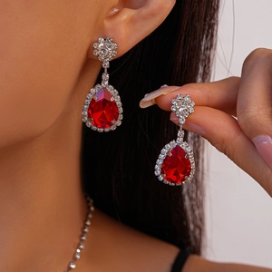 Vue détaillée de boucles d'oreilles vintage avec gemmes rouges et accents diamants
