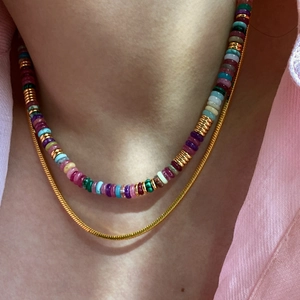 Detail of 18k gold plated snake chain layered with colorful natural stone beaded necklace