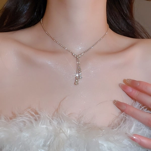 Detailed view of elegant Y-shaped gold necklace with sparkling crystals on model's neck