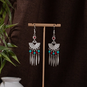 Detail of bohemian silver earrings with turquoise beads and ethnic tassel design