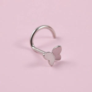 Macro shot of silver stainless steel butterfly nose stud with high-polish finish details