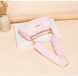 Detailed close-up of pink plush shoulder bag featuring quilted rhombic patterns and gold hardware