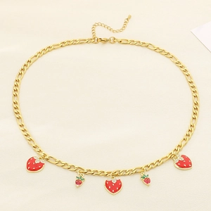 Détail du collier chaîne Figaro dorée avec cinq pendentifs fraises rouges éclatants