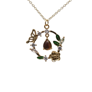 Collier doré avec pendentif papillon, émail vert et pierre aux reflets irisés