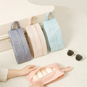 Set of four portable waterproof travel organizer bags in gray, beige, blue, and pink