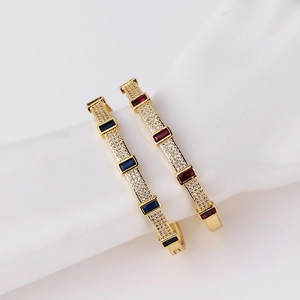 Gold plated cuff bracelet with blue and red rectangular zircons on white hand model