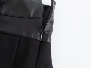 Detailed macro view of black faux leather and fabric patchwork with hidden zipper closure