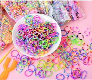 Close-up of DIY rainbow rubber band kit with yellow loom tools and colorful refills