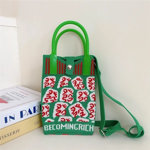 Detail of green knitted phone bag with magnetic snap closure and adjustable strap