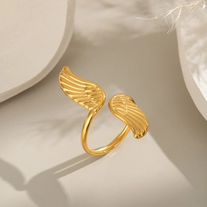 Detailansicht des 18K vergoldeten Engelsflügel-Ringes auf einem minimalistischen Sockel