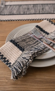 Close-up of woven cotton table runner with fringe details and contrast stitching