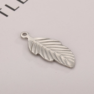 Macro shot of silver stainless steel leaf pendant showing metallic texture and detail
