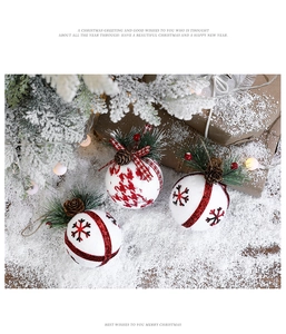 Detail view of red and white Christmas foam balls with pine cones and plaid ribbons
