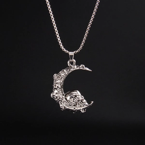 Vue macro détaillée du pendentif croissant de lune argenté avec crâne sur fond noir