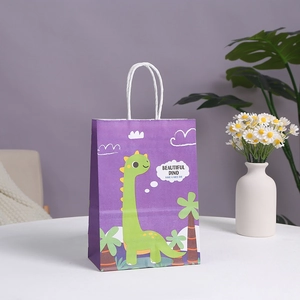 Purple cartoon dinosaur paper gift bag with white handles on a white table