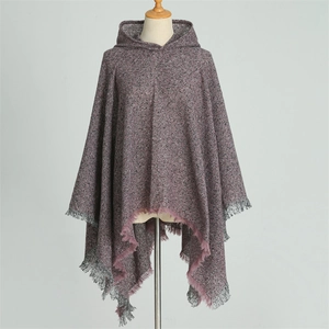 Close-up of fuchsia knit hooded poncho featuring irregular hem and fringed edges